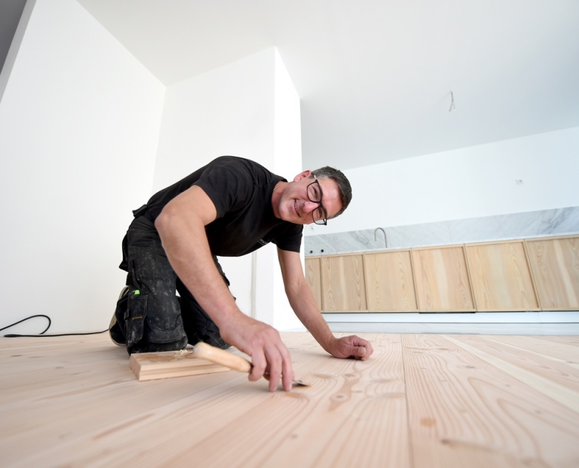 Patrick bearbeitet einen Holzfussboden im Essbereich Patrick bearbeitet einen Holzfussboden im Essbereich